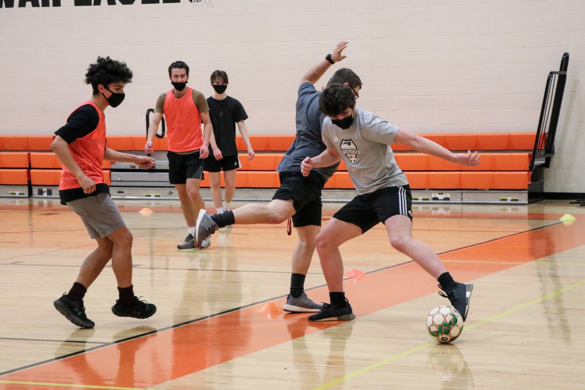 Sophomore Nick Ruff scrimmaging against his coach in soccer practice