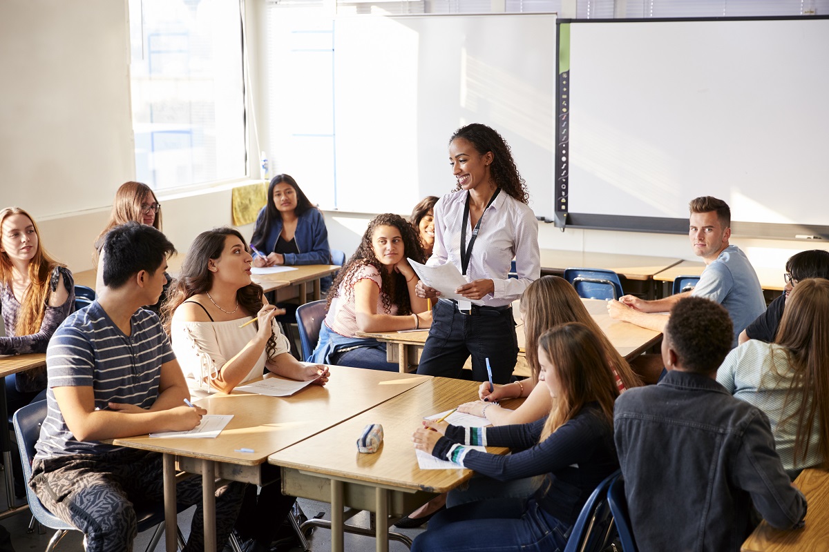 Female High School Teacher Standing By Student Table Teaching Lesson
Image from: study.com