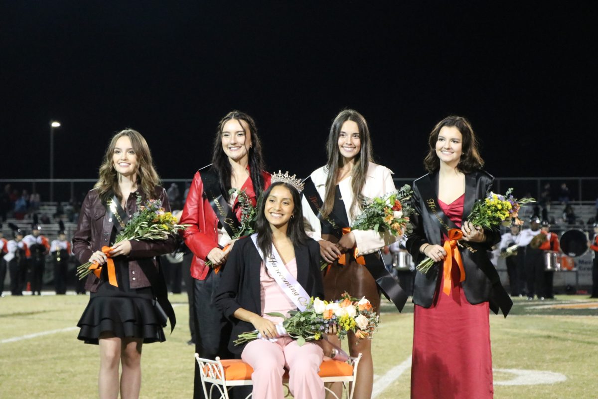 From left to right: Madi Rogers, Reagan Brooks, Sarah West Marklin, and Madelynn Keller pose behind Homecoming Queen Stephanie Bueno-Chiquito following the recognition of the queen and her court.