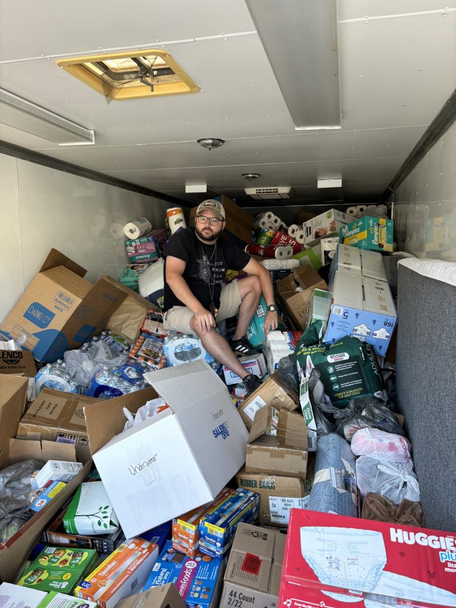 CTE teacher Will Marrs sits on top of a pile of donations. The items, initially intended to go to Watauga County, were rerouted to Newland Fire Department (Avery County, NC). 