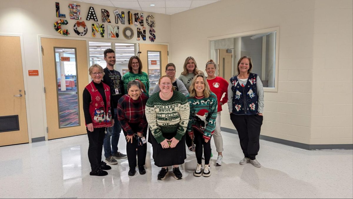 From left to right, in the front Donna Dunn, Kathy Edminson, Kasandra Pond, Lindsey Custer, and Lynn Wisecarver, and in the back Matthew Barker, Ashley Snider, Tani Cuadle, Erica Spry, and Lindsey Sanchez in their ugliest Christmas sweaters