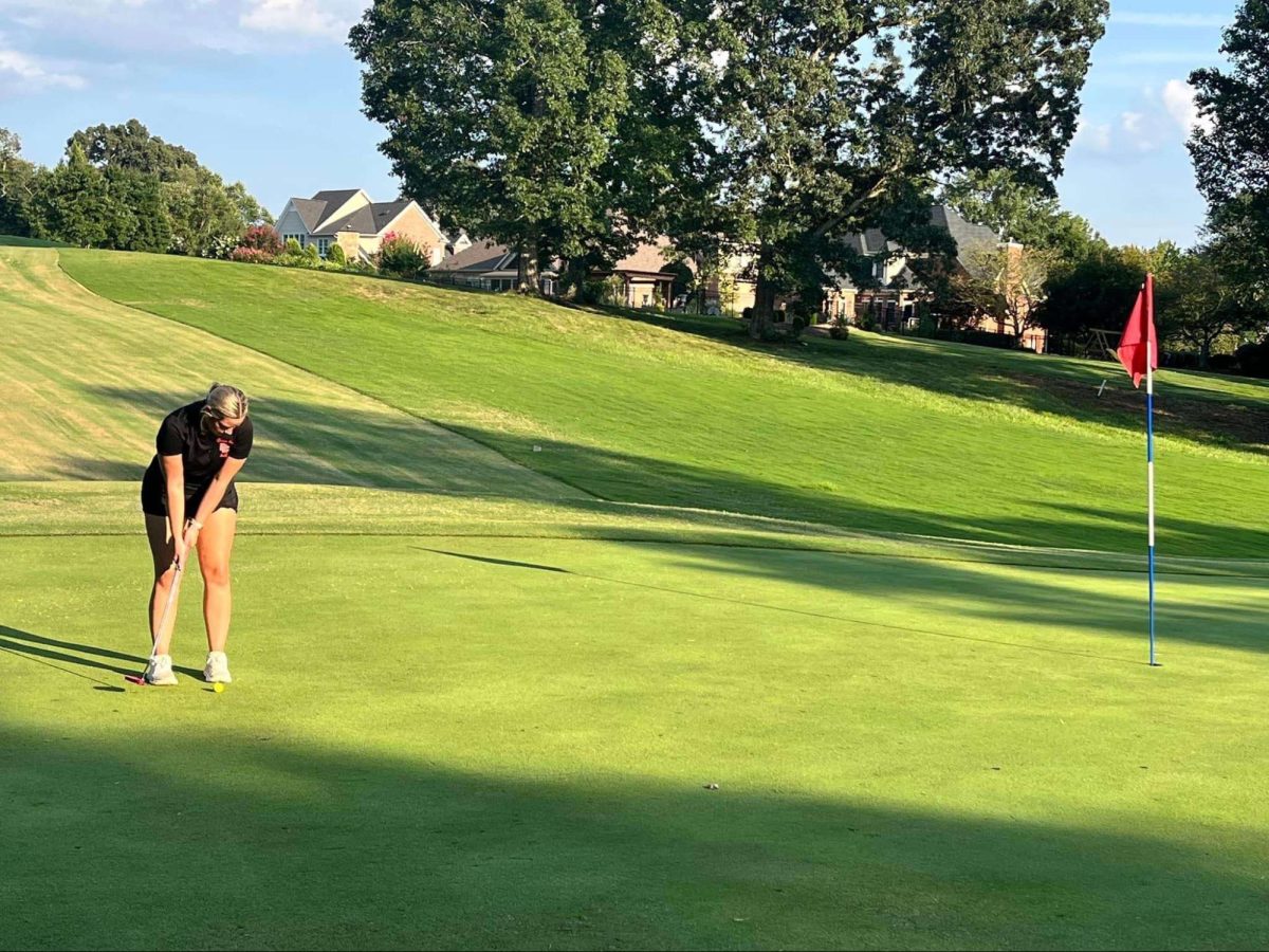 Senior Kayden Cornatzer putting at Bermuda Run West.