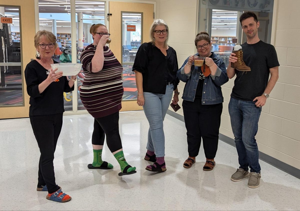 From left to right Donna Dunn, Kasandra Pond, Allison Fender, Tani Caudle, and Matthew Barker show off their unique water bottles while wearing their socks and sandals.