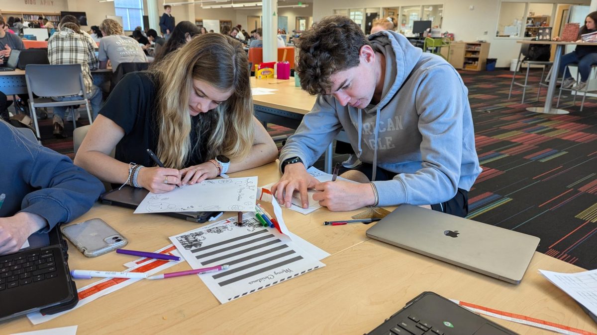 Juniors Lexi Marion and Ethan Lakey work diligently on their letters in the Learning Commons (Santa's Village) in the final days of the letter writing project.