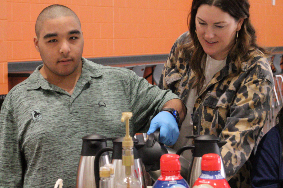 Rebekah Renegar assists her student, BJ Holeman, as he serves staff at Soaring Sips.