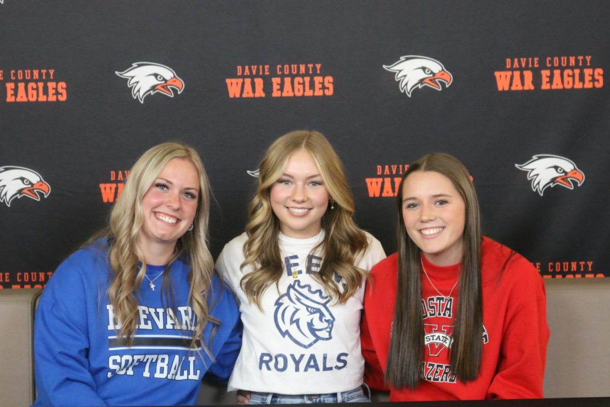 Hanna Steinour, Carleigh Croom, and Riley Potts celebrate their signing to their respective universities in a ceremony in the Learning Commons.