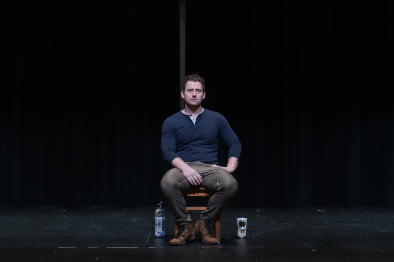 Patrick Osteen of professional theater company RhinoLeap sits center stage in Davie's auditorium ahead of his performance of "An Iliad."