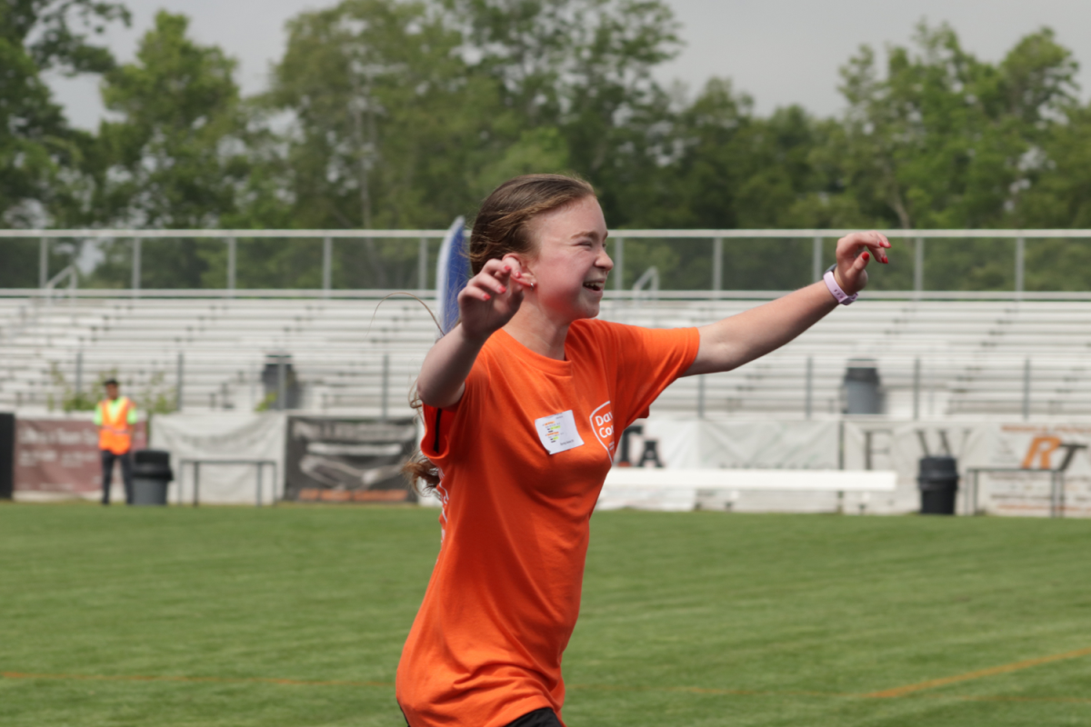 Sophomore Abigail Jepsen soaks in all of the cheering as she crosses the finish line to snag the 1st place spot.