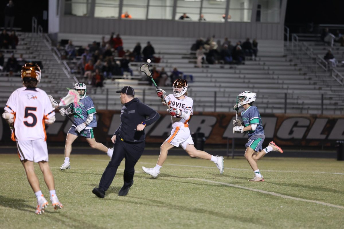 Junior Caswell Moore passes to his teammate after charging down the field.