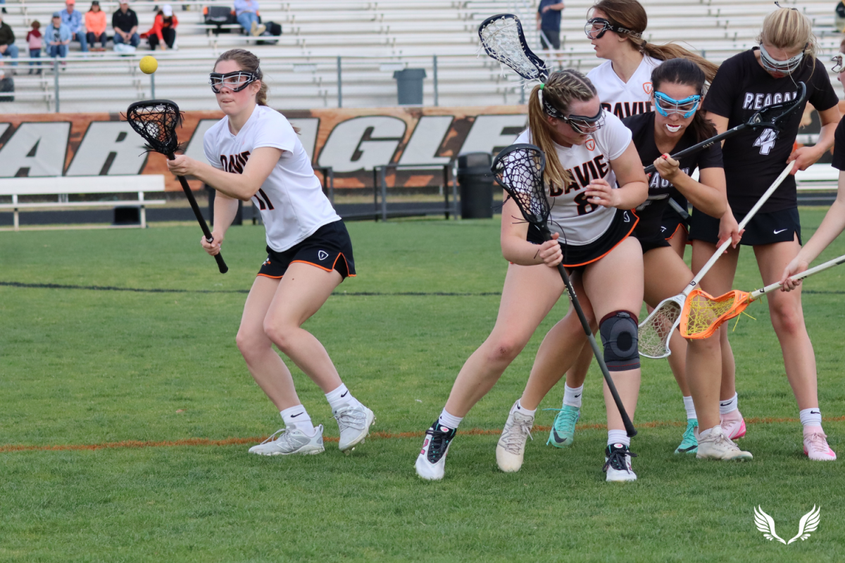 Senior Lyndsay Davis and sophomore Kayden Richardson fight for the ground ball in a match against Reagan High School.