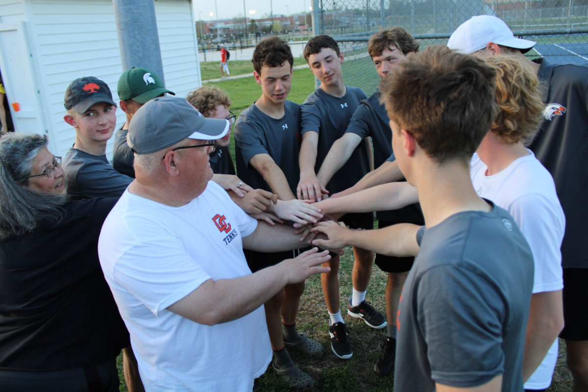 The Men’s Tennis Team huddles for a team send off after a successful match of "Rock-Solid Tennis," the team’s motto. 