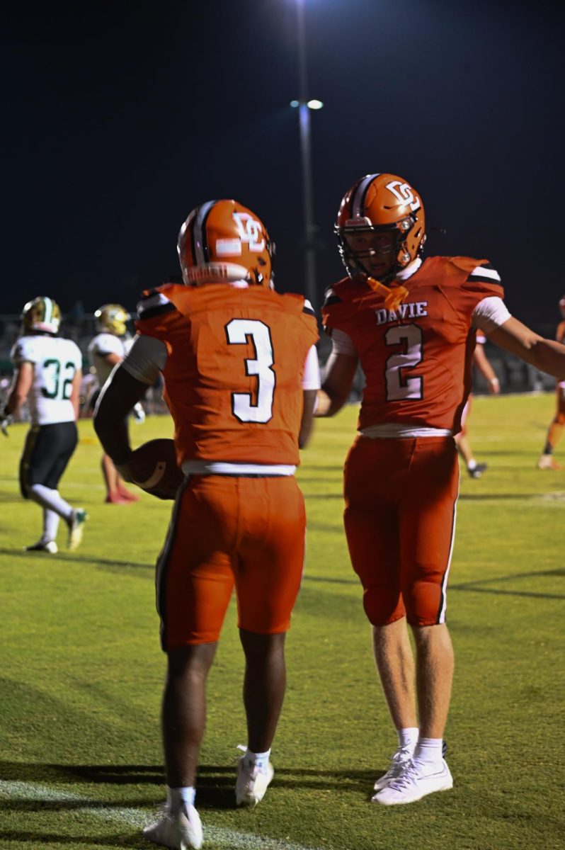 Ethan Driver celebrates with Draeton Nance after he ran the ball down the field and scored a touchdown.