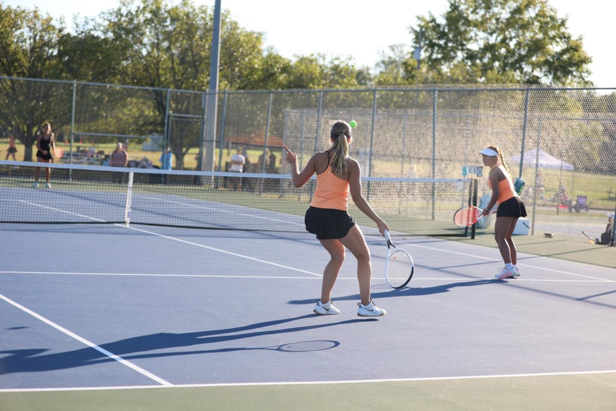 Kate Chaffin and Casey Cao return the ball in a doubles match. 