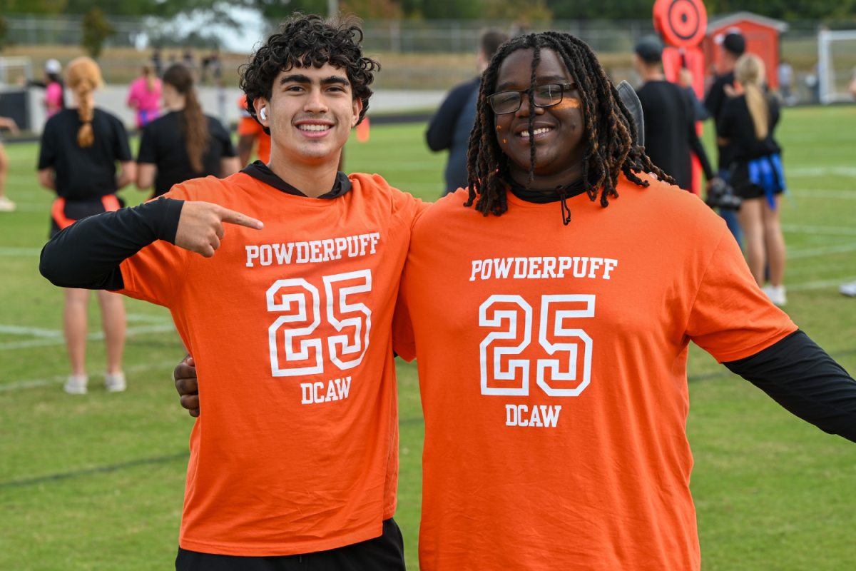 Students Henry Migliarese and Ahmad McGee pose on the sidelines of the Powder Puff Football Game.