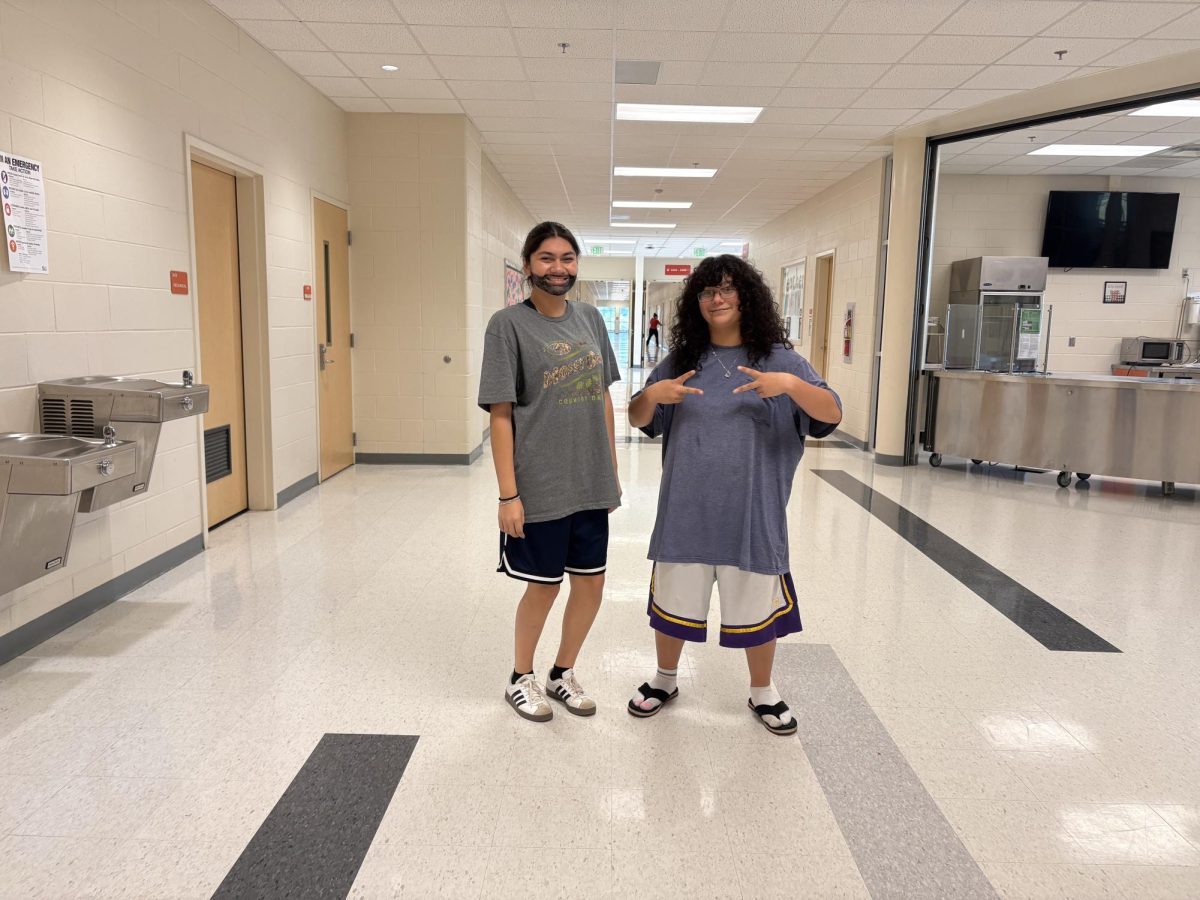 Junior Kiyany Smith strikes a pose with two peace signs, and junior Elizabeth Ramirez gives a beardy grin in their Adam Sandler outfits.