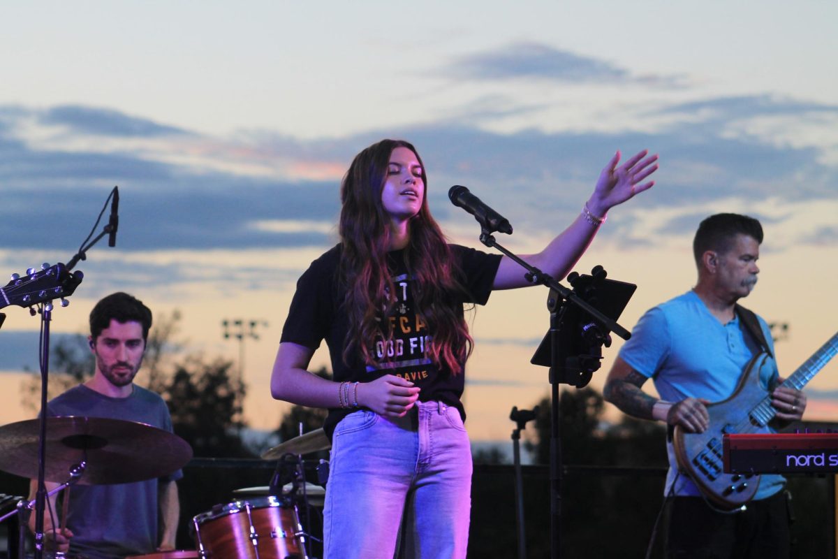 After the first round of testimonies, student leader and head of the worship music team at FCA, Ava Jane Tomlinson, led the community in singing various worship songs. In an interview, Tomlinson said that the opportunity to lead the community by singing was an important part of the night because it brought people together. “I think it’s so cool to get to see so many people from our community worship our God, and I feel like it’s a really important part of my relationship with Christ,” Tomlinson said. “I want to give that to other people, and Fields of Faith gave me a really cool opportunity to do that, and to also show people that young people can lead worship too.” Tomlinson also discussed how her opportunity to sing impacted both her and those in attendance. “To be able to express my faith and worship through music has helped me grow so much as a leader,” Tomlinson said. “A lot of people came up to me afterwards and told me that they were really moved by the music. I think my being a student leader really helped people see the impact.”