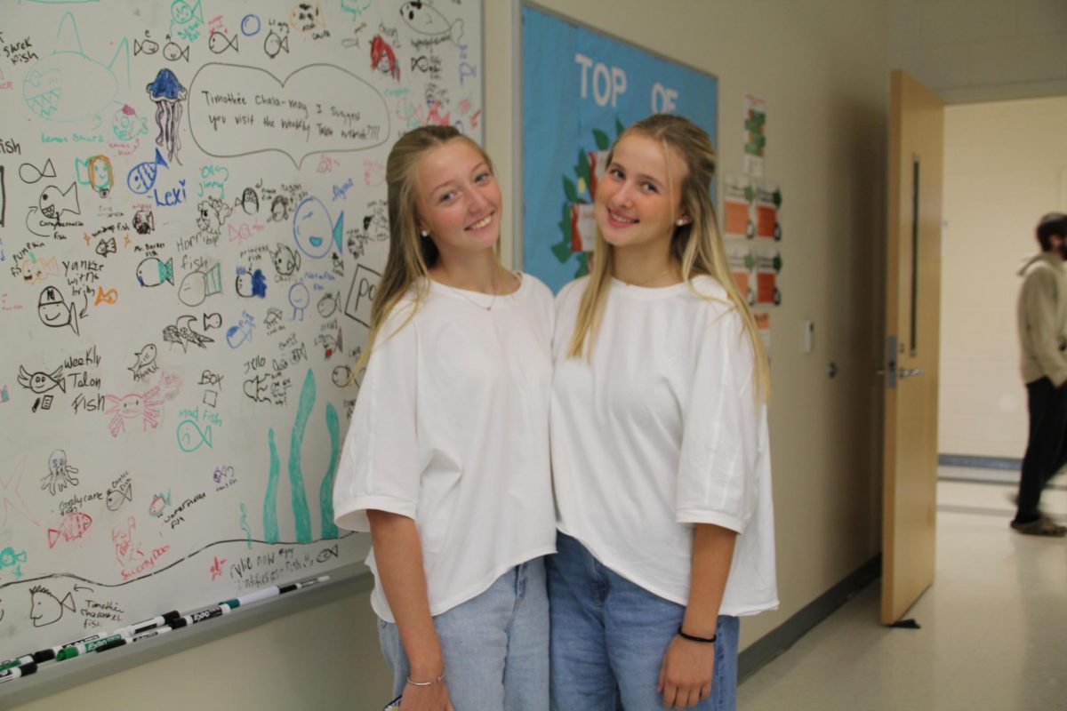 Sophomores Lilah Keaton and Addison Connell pose in Matt Barker’s room in their white t-shirts, jeans and pearl earrings.