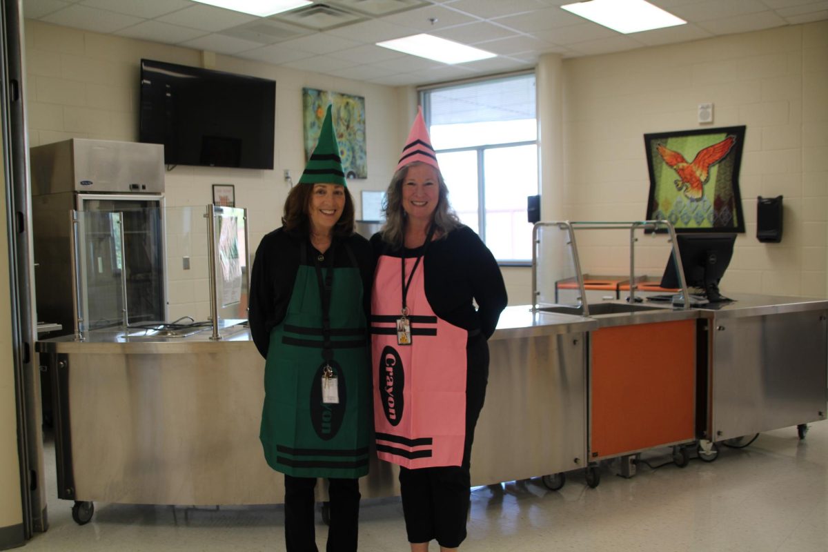 Two teachers are dressed like crayons matching with some of their other teacher friends.