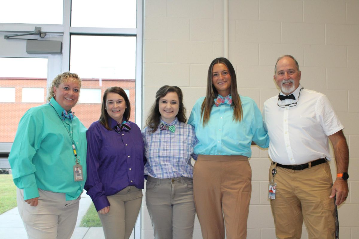 CTE teachers are gathered in front of the windows in their best Alvin Rubin fits.
