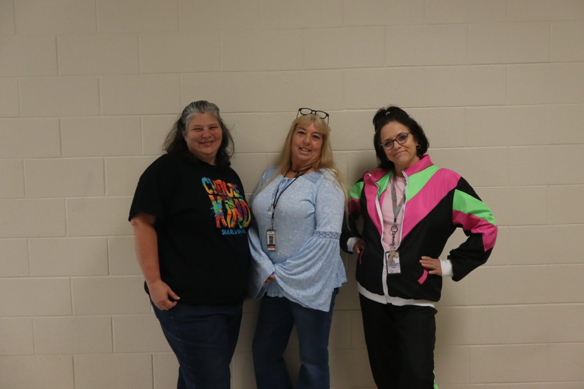 Teachers Melissa Boswell, Colleen Pitts, and another teacher are dressed in their best decades costumes featuring outfits from the 70s, 80s, and 90s.