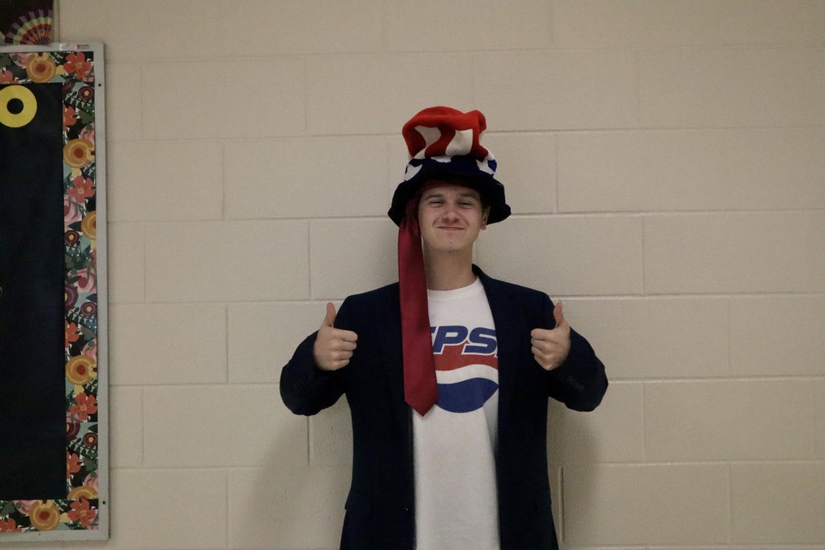  Junior Caleb McCullar holds two thumbs up for his USA day outfit, sporting a Pepsi shirt and an American flag hat. 