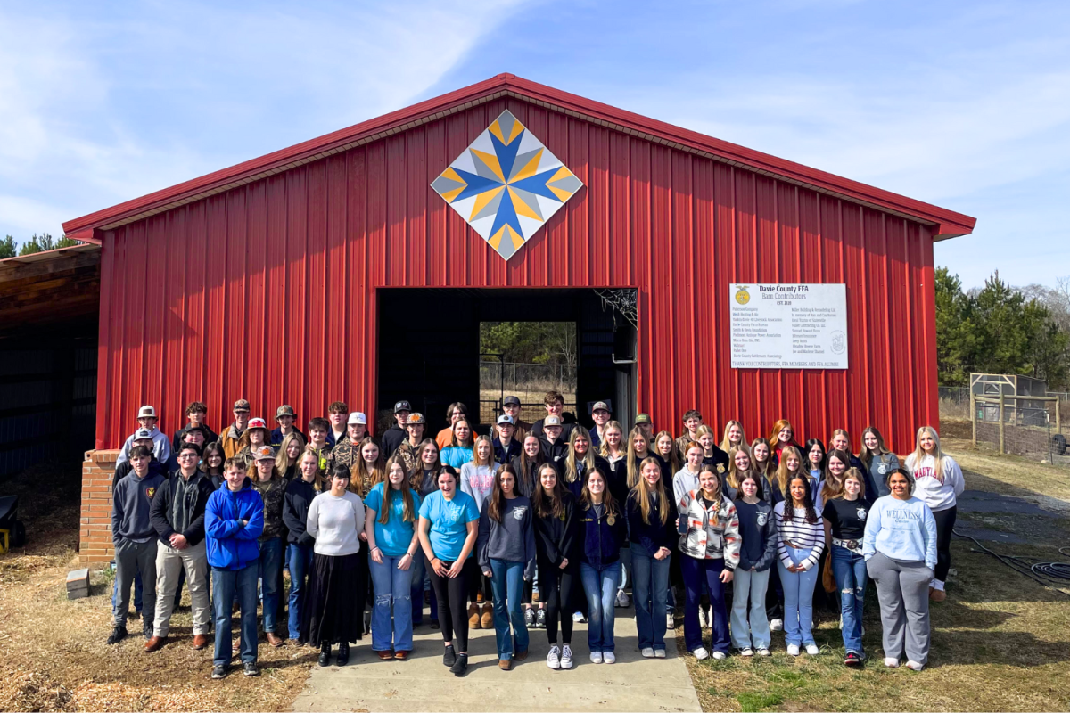 Members of Davie High's chapter of FFA pose in front of the barn built through contributions by various chapter members.