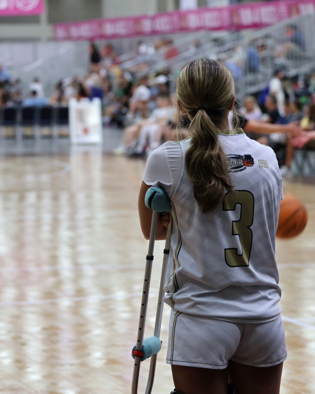 Senior Bailey Aderhold stands courtside at a Winston-Salem Stealers game after her ACL surgery.