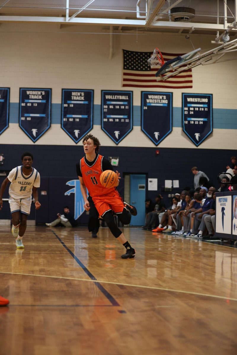 Rushing down the court, junior Aiden Horton dribbles the ball ready to make the play.
