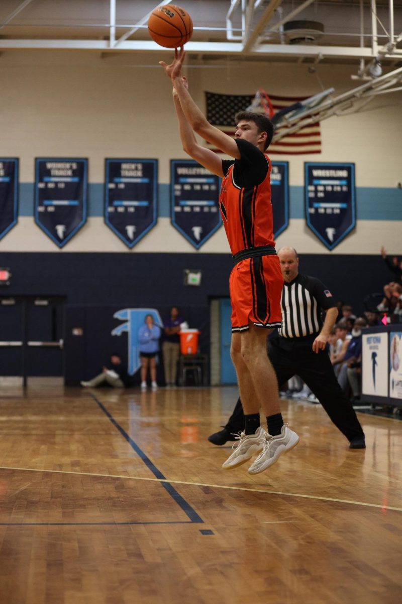 Shooting from the 3-point line, junior Ian Patton rises up and makes the basket.