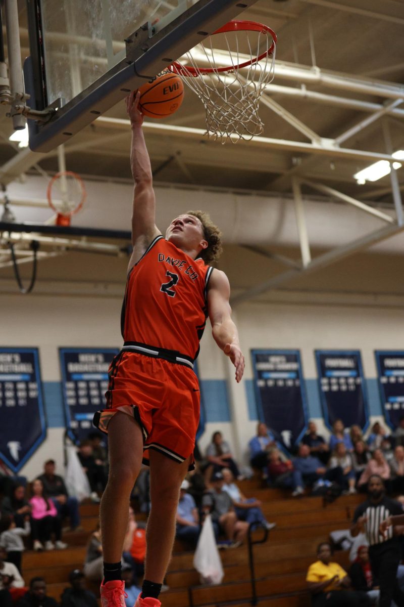 In the air, senior Ethan Driver touches the backboard, scoring two points and making the layup.
