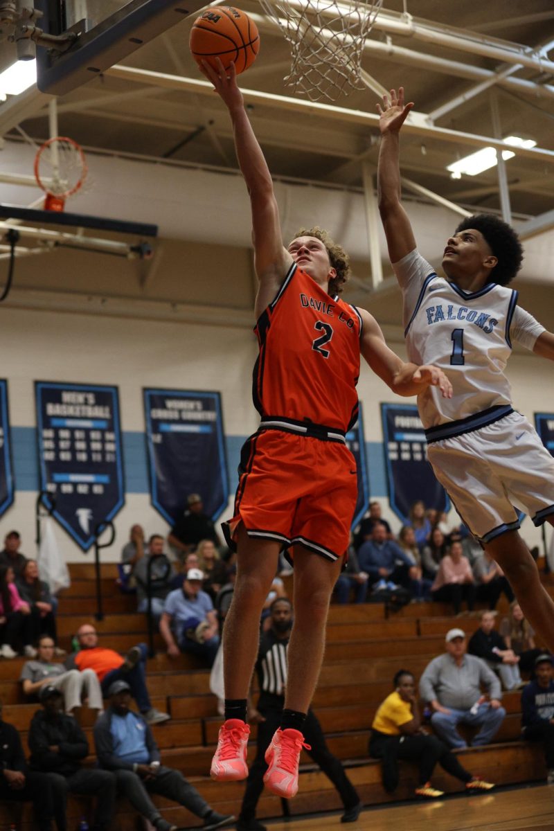On the verge of making the layup, senior Ethan Driver manages to jump into the air and deflect his defender. 