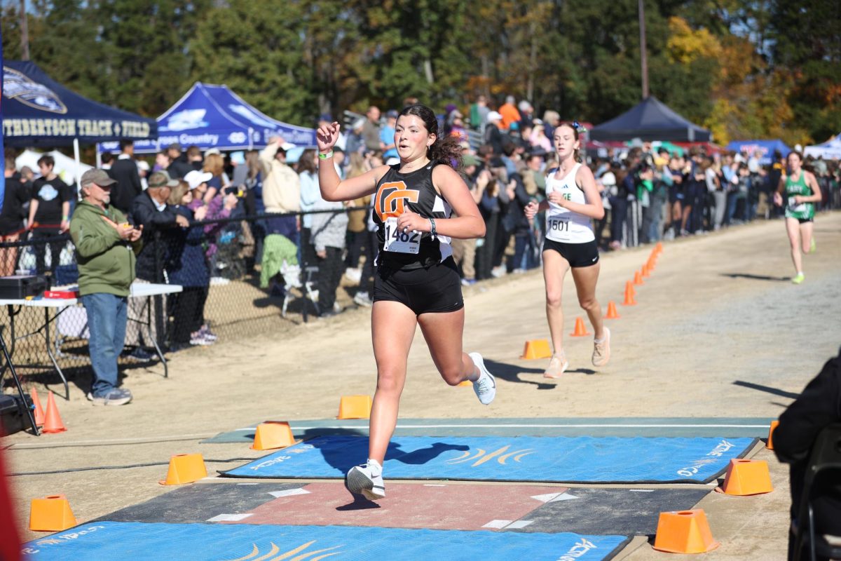 Rachel Starkey takes her final stride as she crosses the finish line, completing the state championship race. 