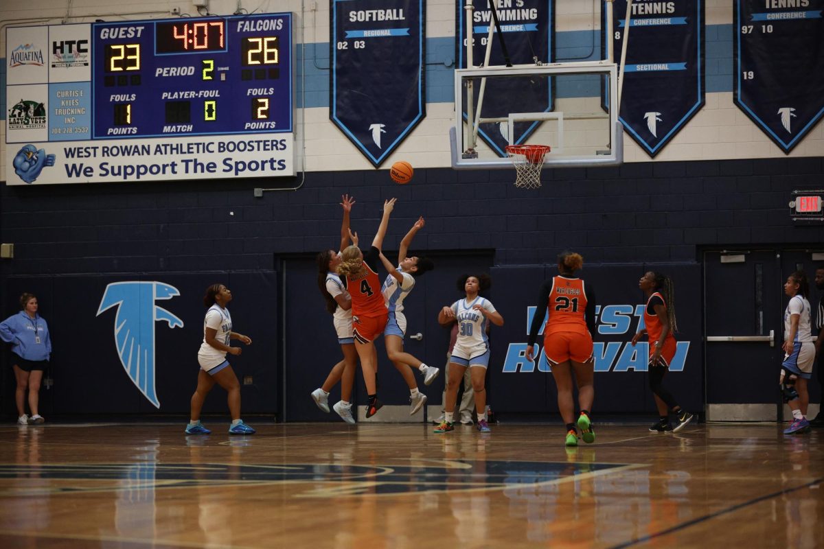 Junior Emmie Burris rising above two defensive Falcons and scoring two points for the War Eagles.