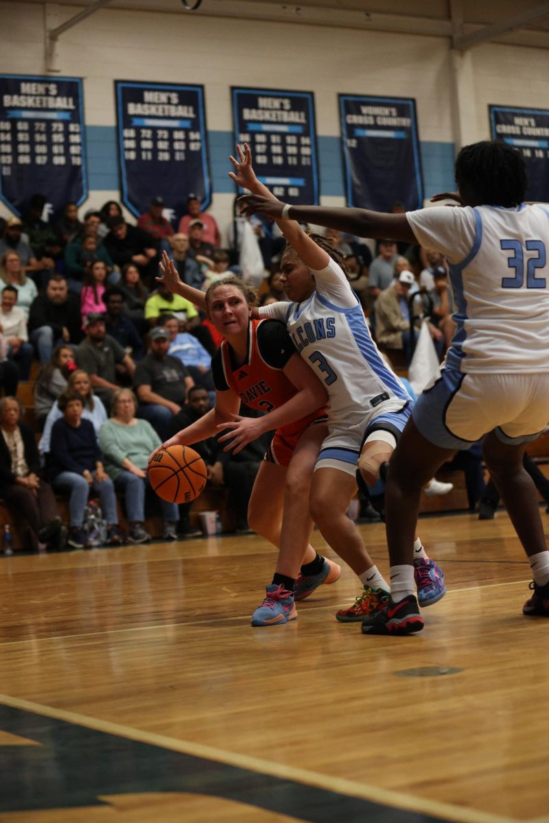 Fighting the Falcons' defense, junior Lexi Mickey dribbles the ball to make the shot.