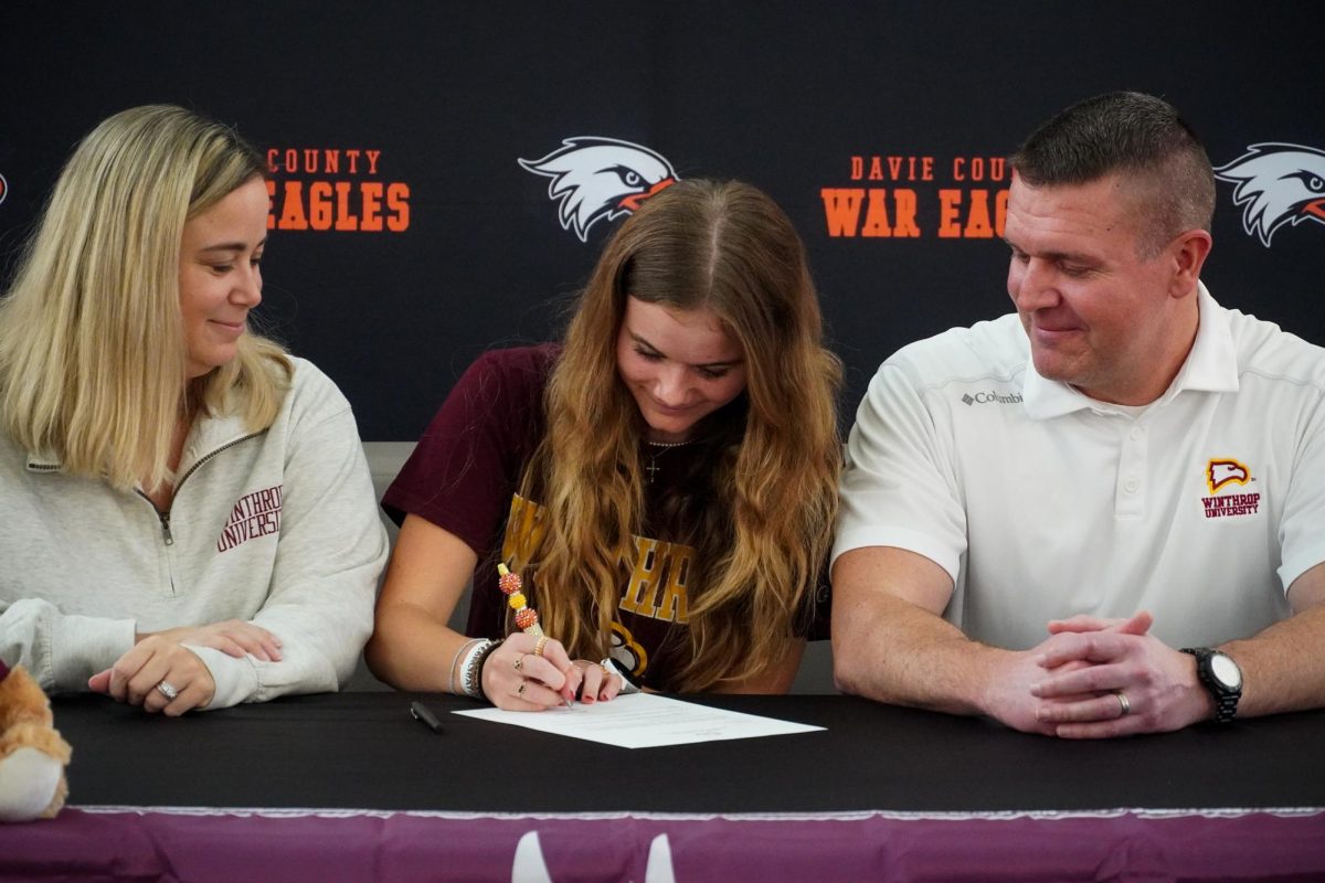 Lexi Marion signs to Winthrop University to be a member of their cross country and track team surrounded by her parents. 