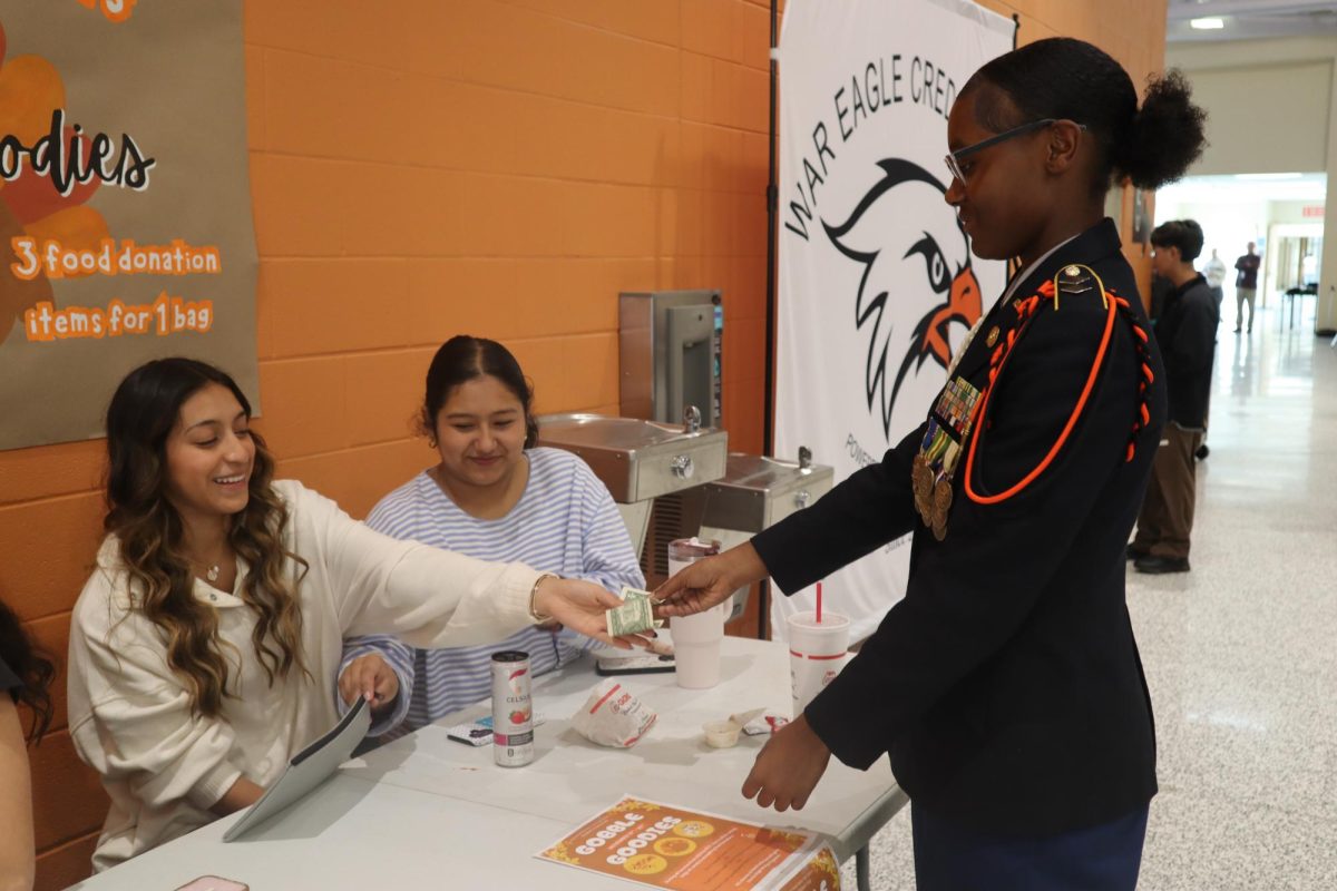 Senior Emily Bueno hands money back to senior Jamie Brown after she purchased a goodie bag. 
