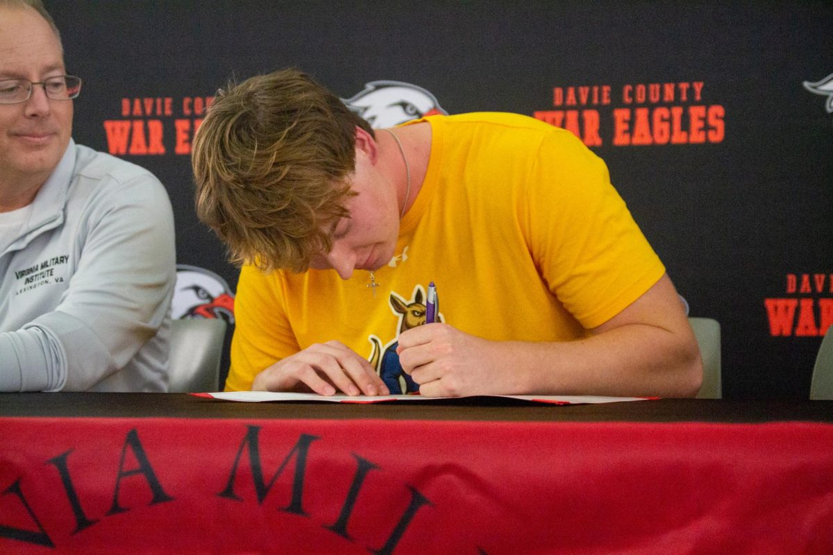 Men's lacrosse senior Jack Pisciotta signs his letter of intent to play at Virginia Military Institute at a ceremony in the DHS learning commons after school November 21.