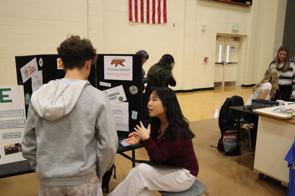 Sophomore Trista Yang speaks with a student about Science Club at the inaugural club fair.