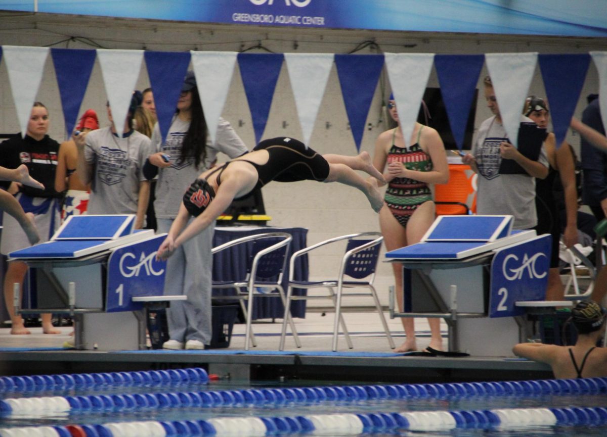 Junior Olivia Dufur dives into the pool, starting her race. 
