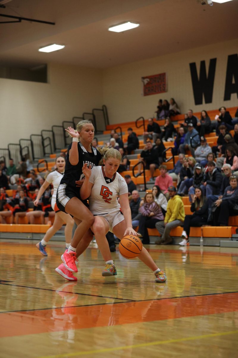 Pushing back the Panthers defense during the 1st quarter, Junior Emmie Burris dribbles towards the hoop.
