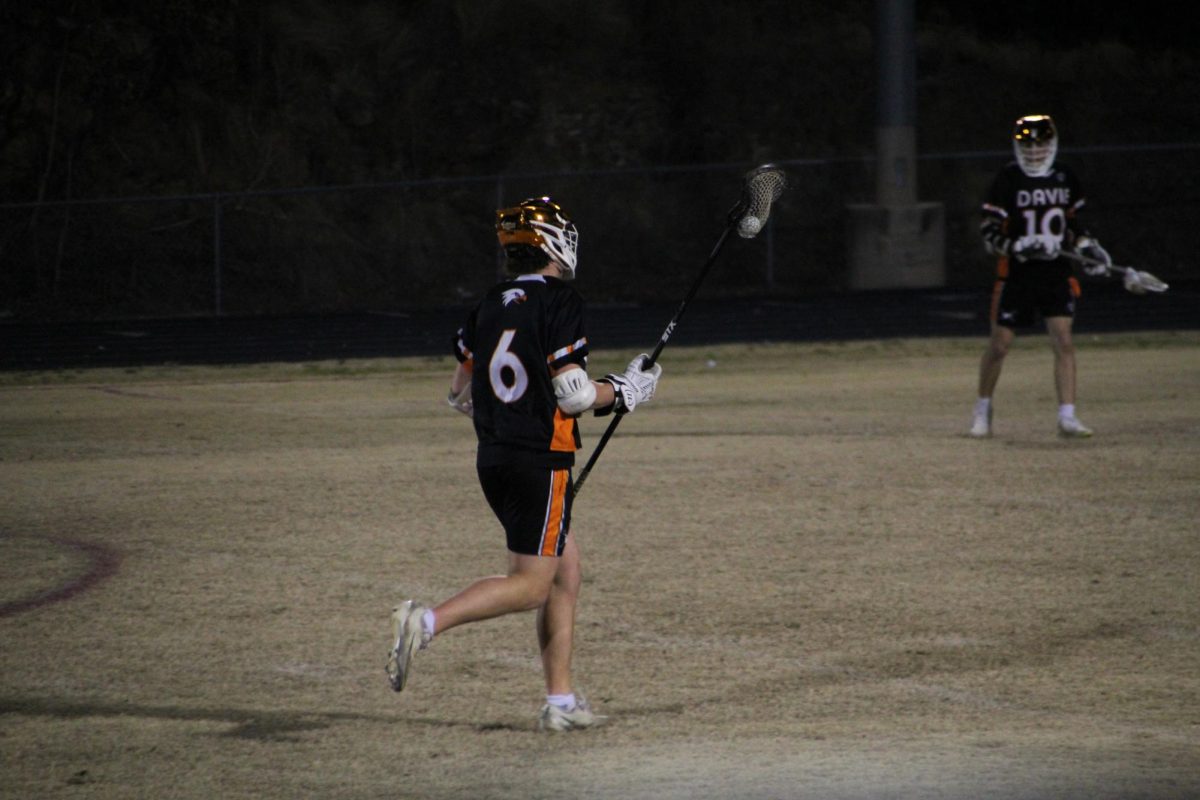 Junior Evan Helms cradles the ball down the field transitioning Davie to play offense.  