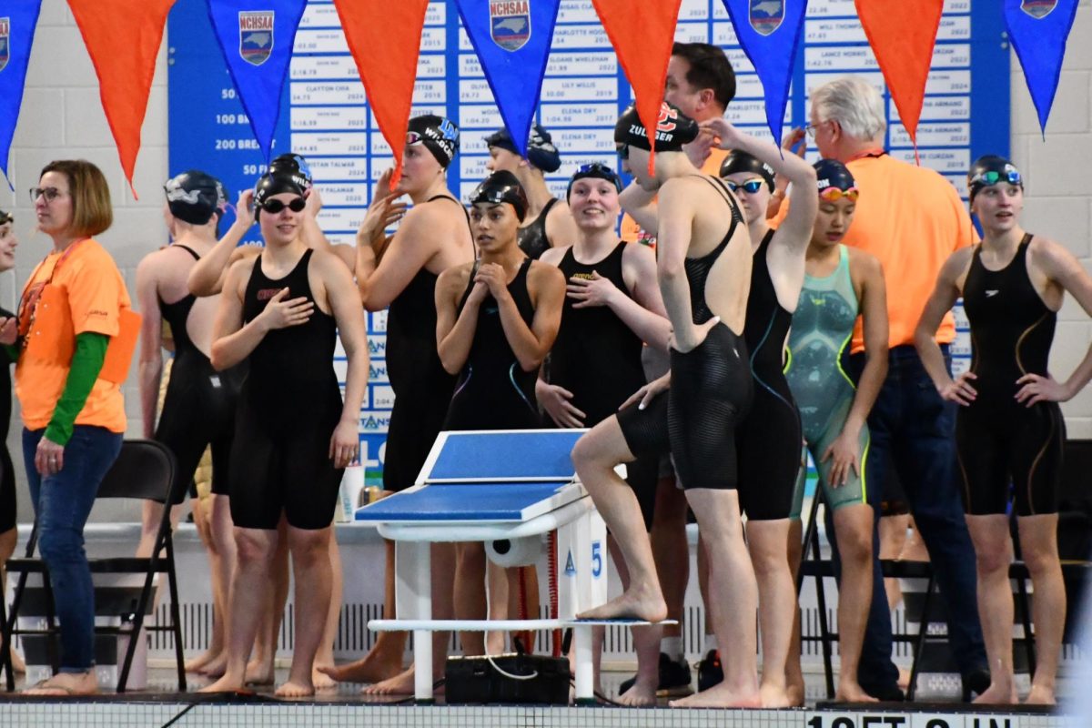 The Women's 200 Freestyle Relay shake out pre-race nerves behind the block preparing for their relay leg. The relay consists of junior Samara McDaniel, junior Olivia Dufur, sophomore Emory Butler, and sophomore Skylar Zuleger. 