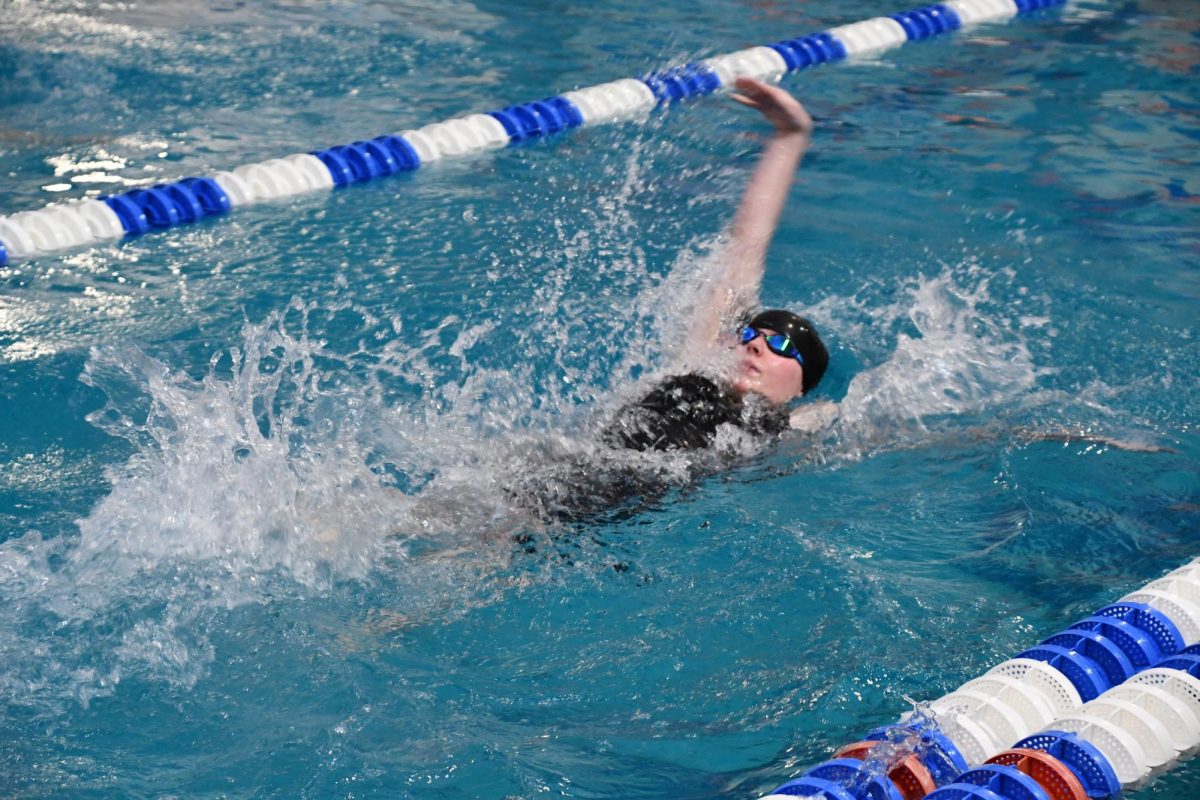 Sophomore Emory Butler races in the 100 Backstroke hoping to get a personal record. 