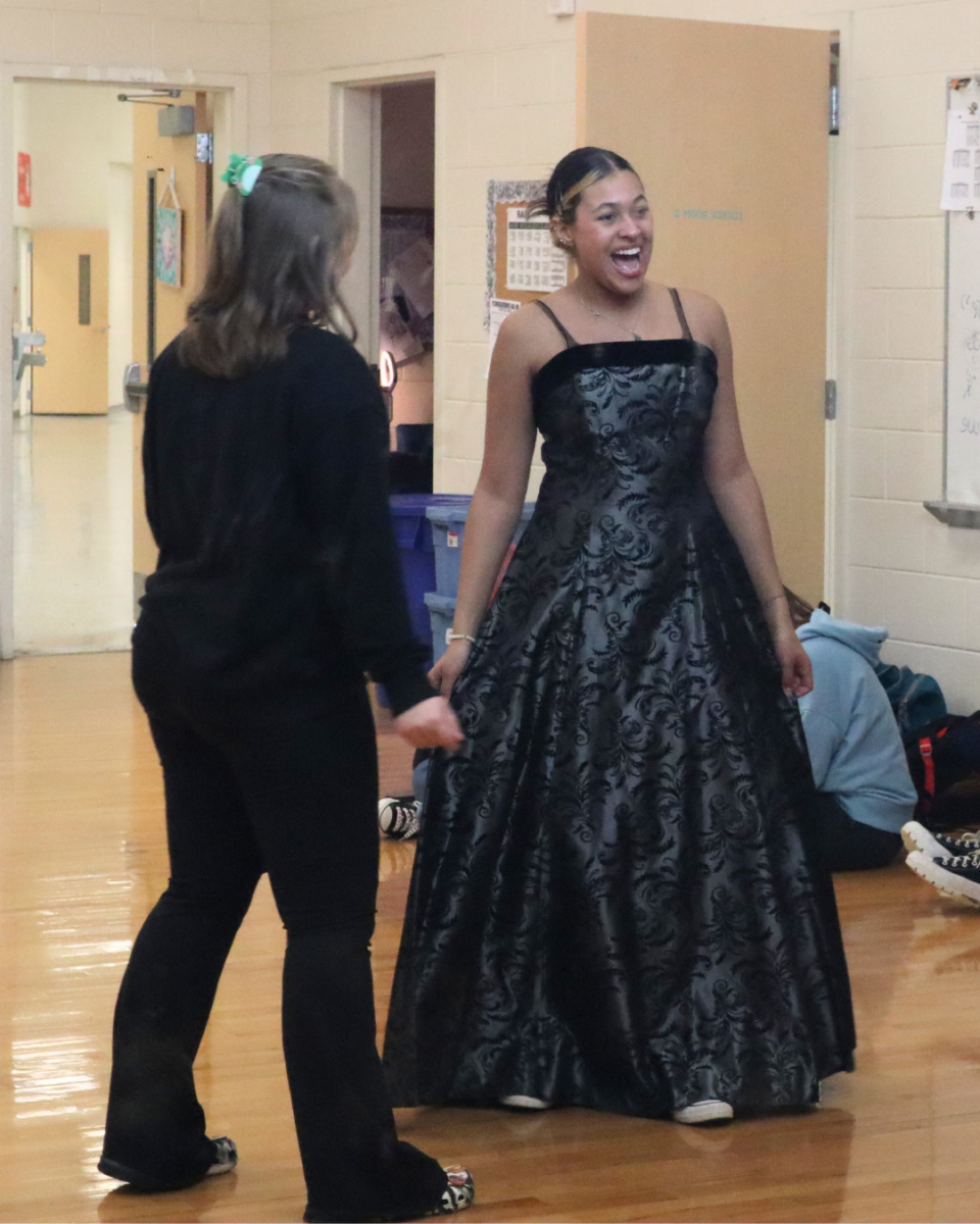 Senior Allyson Phibbs assists senior Shyla Martin in trying on her dress.