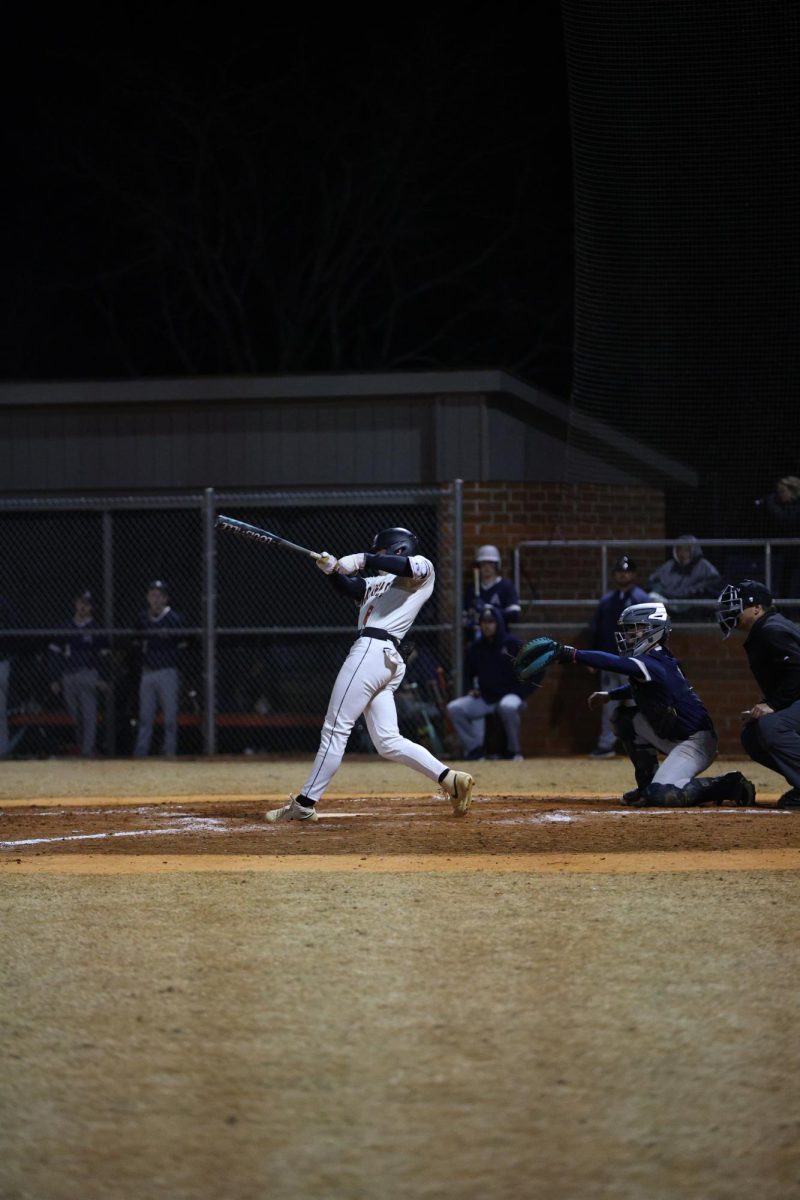 As Senior John Fisher's eyes land on the ball, he completes a powerful swing. 
