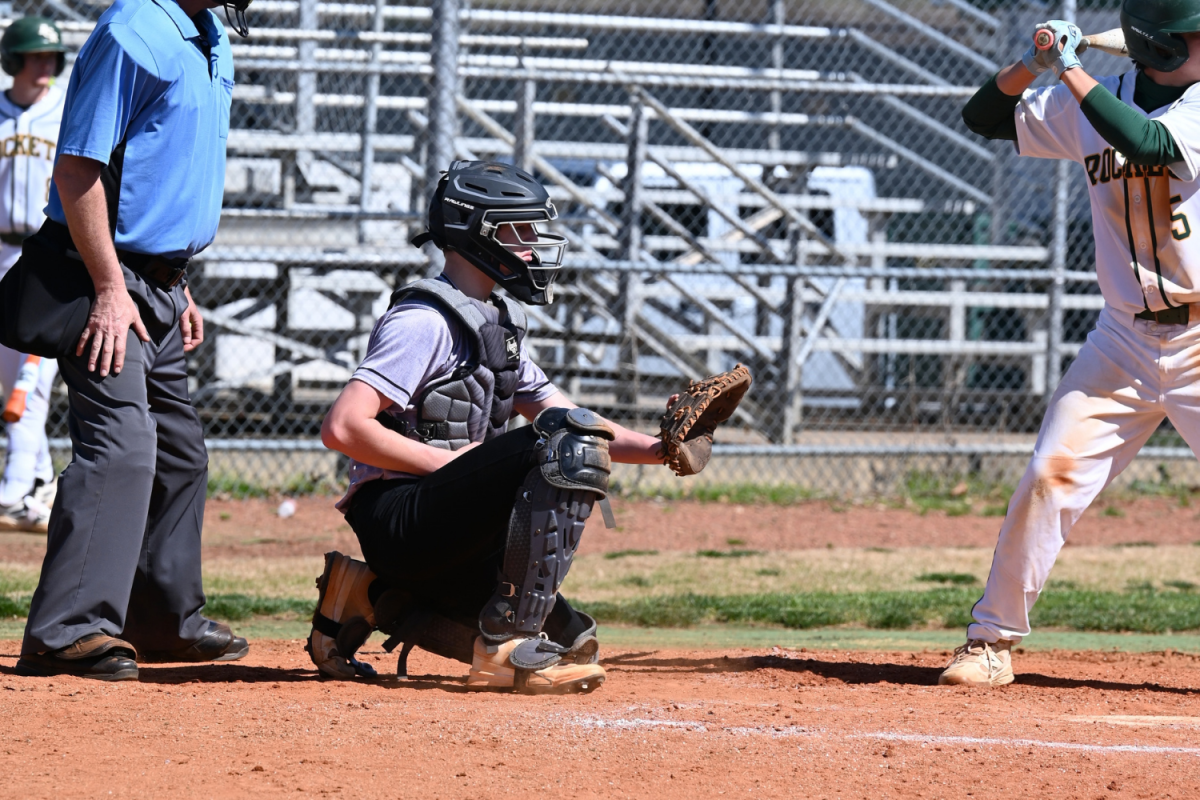 Jason Riddle gets ready to catch the ball as the pitcher throws it.