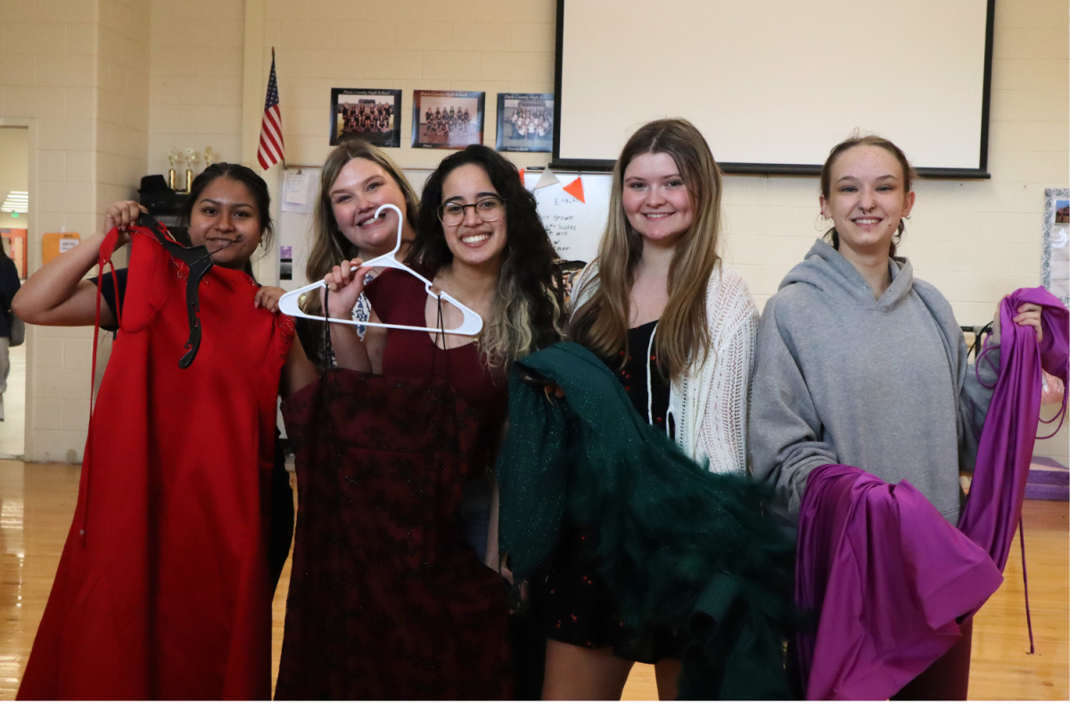Emily Reyes, Angelina Perez, Makayla Frye, and Kayden Ijames  pose with event organizer Erica Spry and their new dresses.