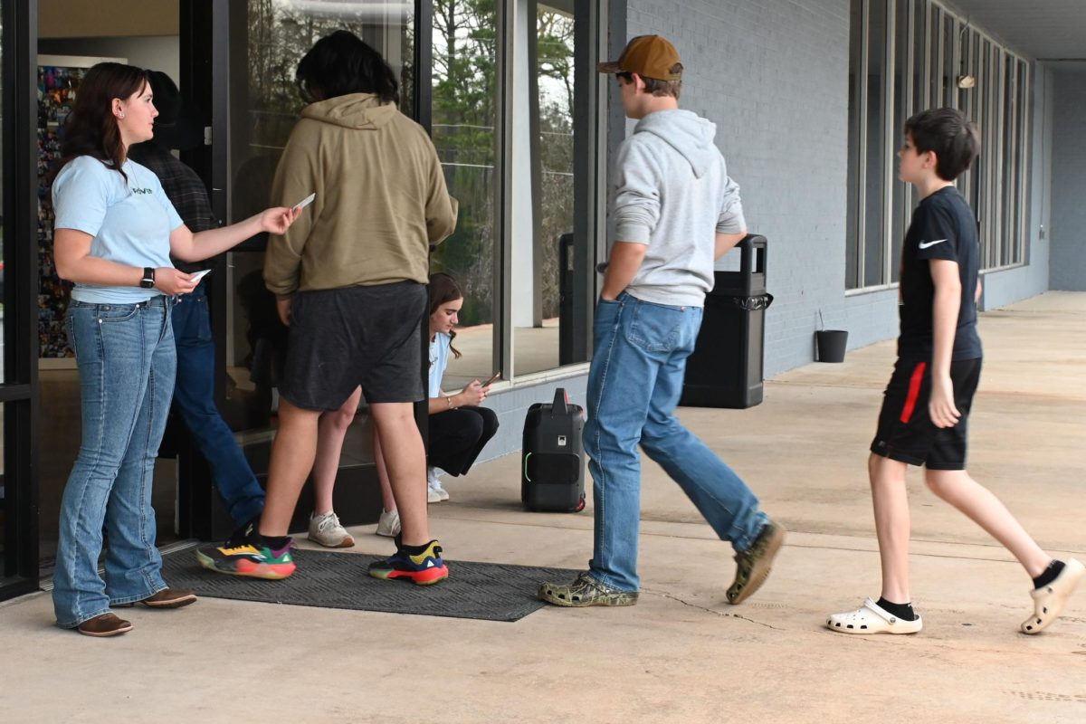 FCA student leaders greets people at the door of the event, sharing smiles to welcome everyone. 