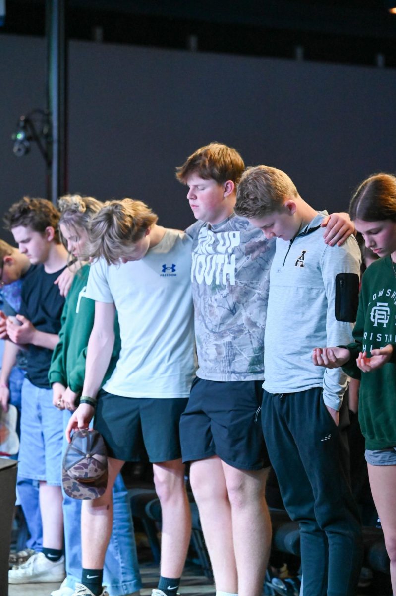 Davie High students wrap their arms around their community during worship. 