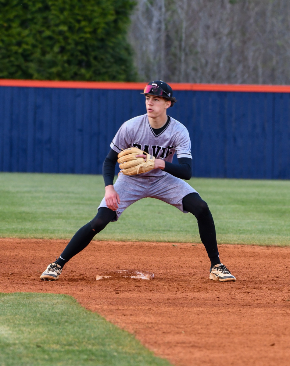 Hayden Potts gets ready to catch the ball as Tanner Steinour the catcher throws the ball.